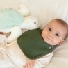 Bebé com o seu babete verde-azeitona e a sua tartaruga de peluche