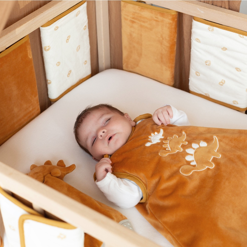 Bebé na cama com os protetores das grades colocados Bebé na cama com os protetores das grades colocados
