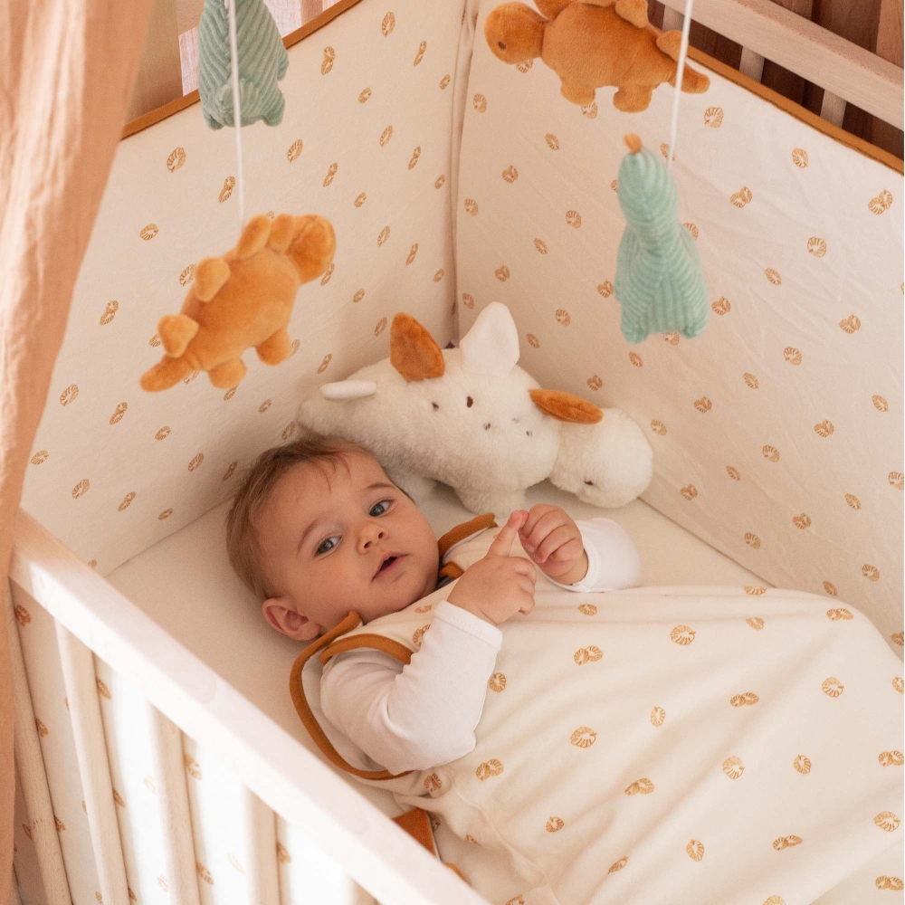 Baby playing in crib wearing a sleep sack Baby playing in crib wearing a sleep sack