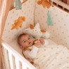 Baby playing in crib wearing a sleep sack Baby playing in crib wearing a sleep sack
