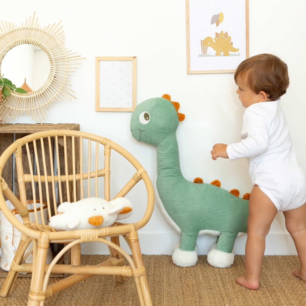 Bebé ao lado da sua grande peluche de diplodoco Bebé ao lado da sua grande peluche de diplodoco