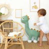 Bebé ao lado da sua grande peluche de diplodoco Bebé ao lado da sua grande peluche de diplodoco