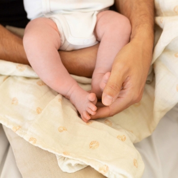 Papa umhüllt Baby mit seinem Arm