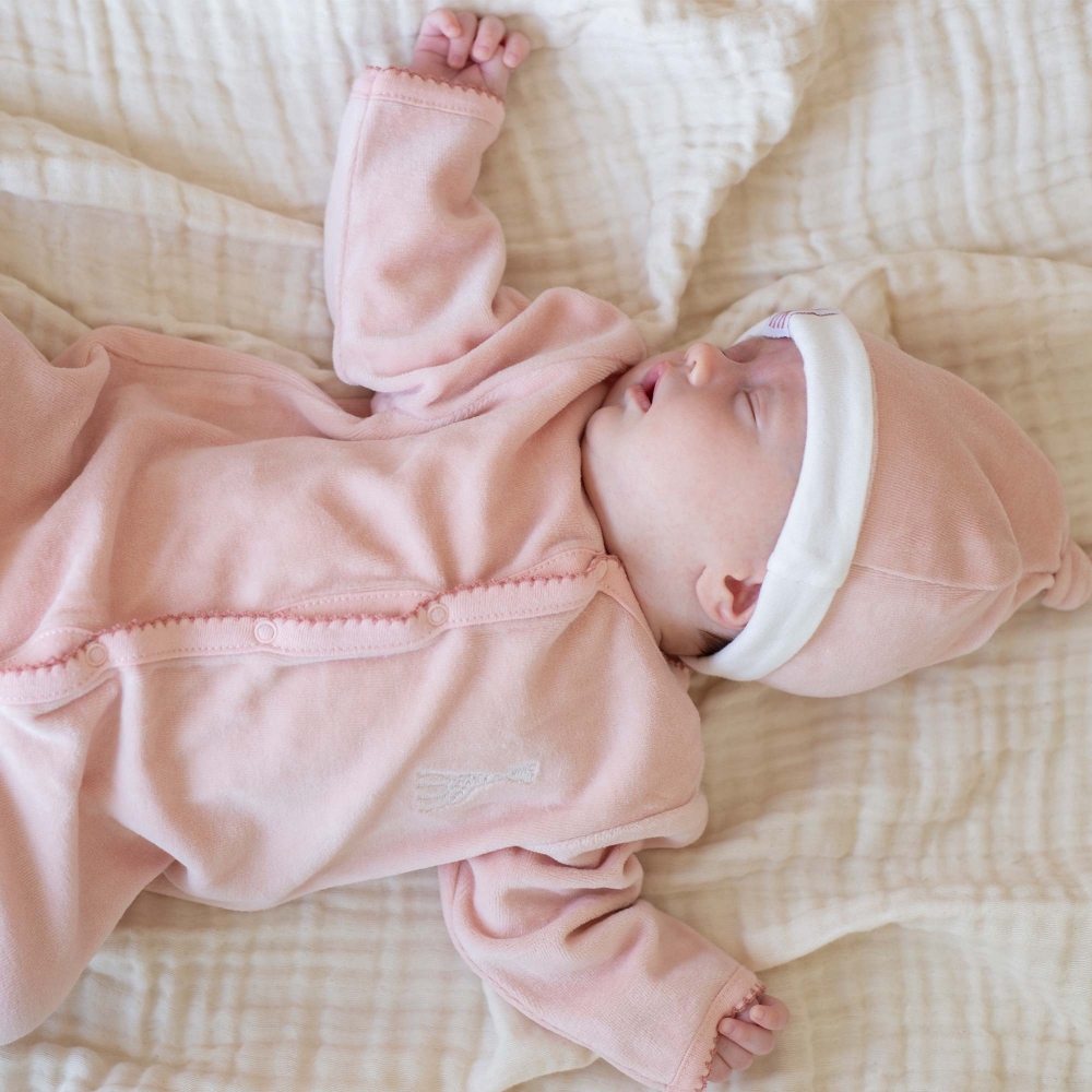 Bebé a dormir com o seu pijama rosa e gorro rosa Sophie la Girafe