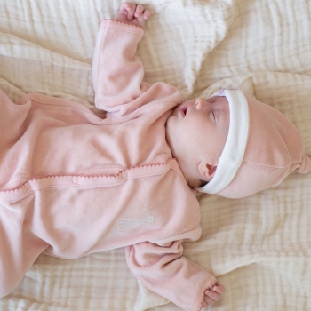 Il bambino dorme con il pigiama rosa e il cappello rosa sophie la giraffa