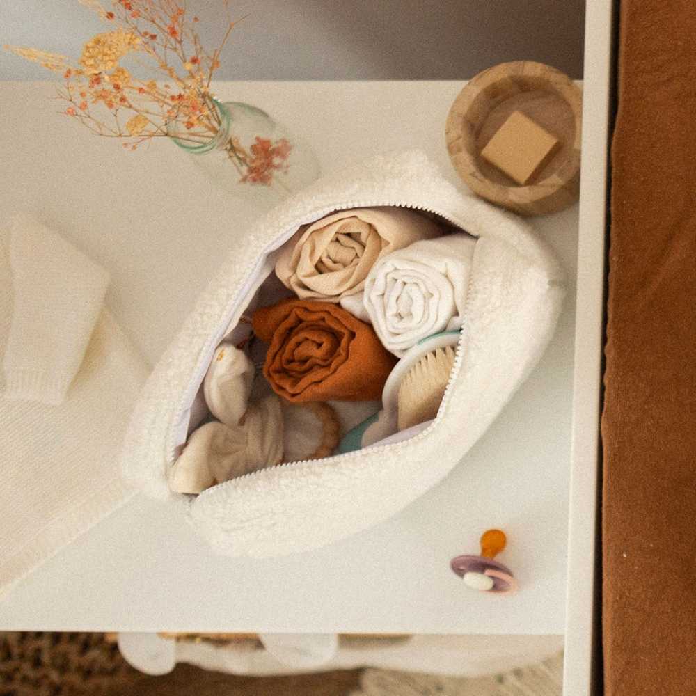 Bolsa de higiene para bebé aberta com os artigos essenciais para o bebé. Bolsa de higiene para bebé aberta com os artigos essenciais para o bebé.
