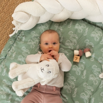 baby met zijn schapenknuffel op zijn speelkleed baby met zijn schapenknuffel op zijn speelkleed