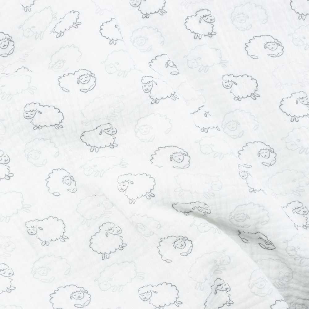 Pormenor do tecido e dos motivos da manta branca para bebé