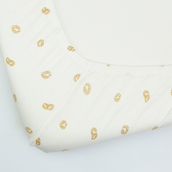 Sábana bajera color crudo con motivos de hojas