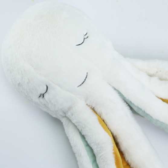 peluche em forma de polvo chamado Poulpie, em bege, mostarda e verde-água