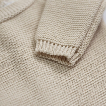 détail de la manche de la brassière bébé couleur sable