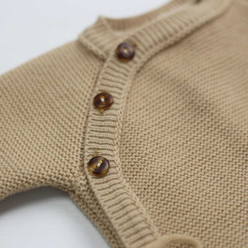 detail van de knoopjes van de gebreide babyromper detail van de knoopjes van de gebreide babyromper