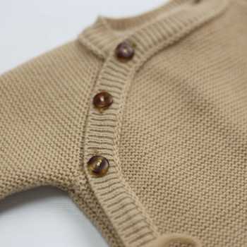 detail van de knoopjes van de gebreide babyromper