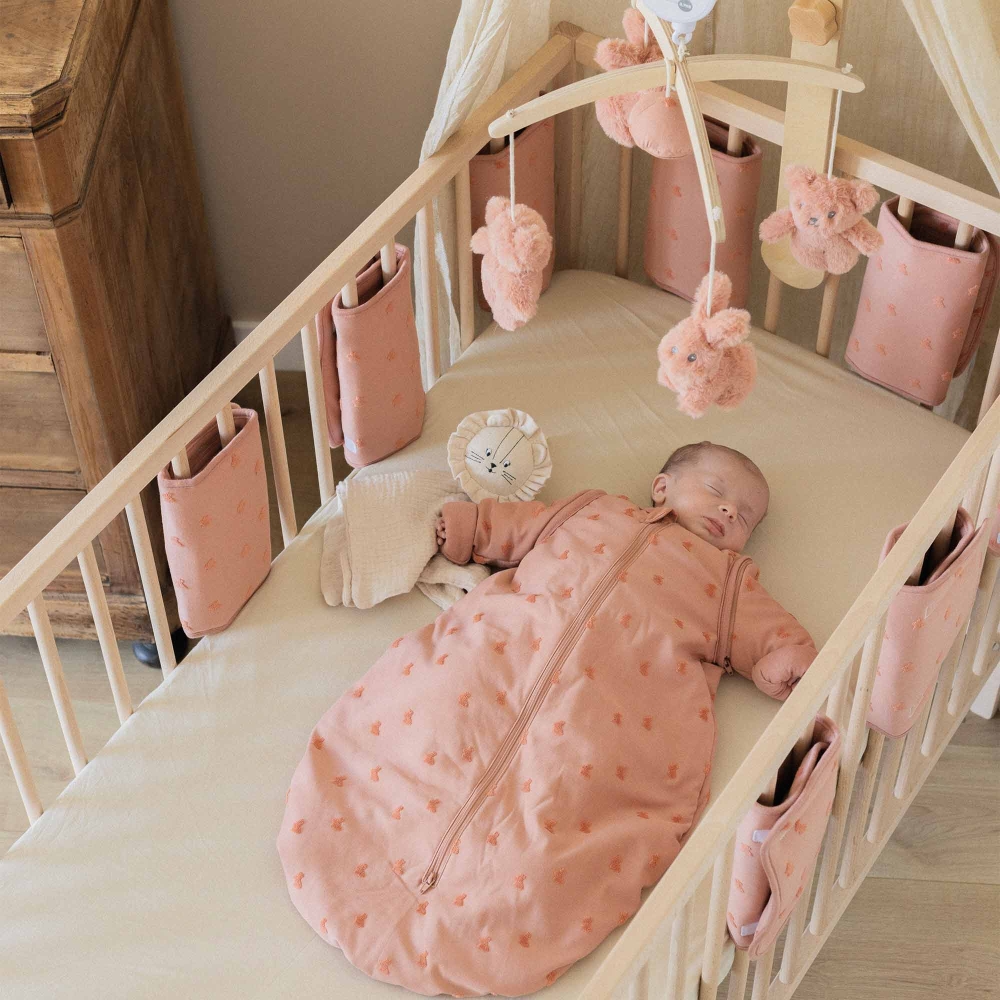 Baby in seinem Bett mit seinem Schlafsack der Kollektion Hop Baby in seinem Bett mit seinem Schlafsack der Kollektion Hop