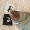 Baby kijkt naar zijn boek in zijn slaapzak Baby kijkt naar zijn boek in zijn slaapzak