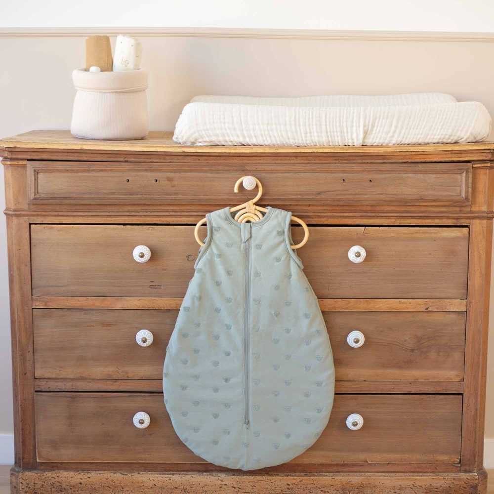 Saco de dormir para bebé apresentado sobre uma cómoda de bebé