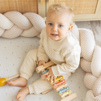 baby speelt met zijn decoratieve vlecht achter hem baby speelt met zijn decoratieve vlecht achter hem