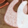 Pormenor dos motivos dos babetes para os primeiros meses em rosa e branco