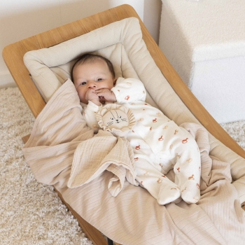 bambino nel suo sdraietto in pigiama con la sua coperta