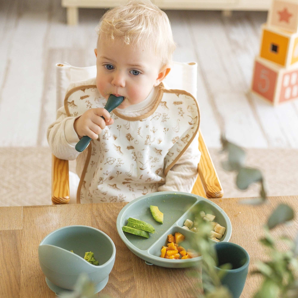 bébé mange et s'aide de sa cuillère en silicone