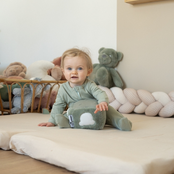 bebé a brincar com um cubo de atividades, vestido com um pijama de algodão verde-sálvia bebé a brincar com um cubo de atividades, vestido com um pijama de algodão verde-sálvia