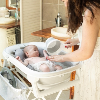 baby in the bath with mom rinsing baby baby in the bath with mom rinsing baby