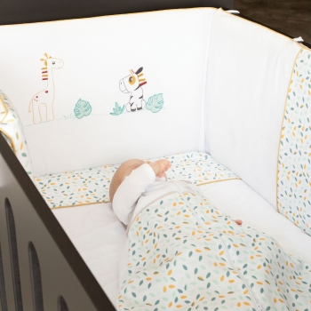 Bettumrandung in einem schwarzen Babybett mit schlafendem Baby Bettumrandung in einem schwarzen Babybett mit schlafendem Baby