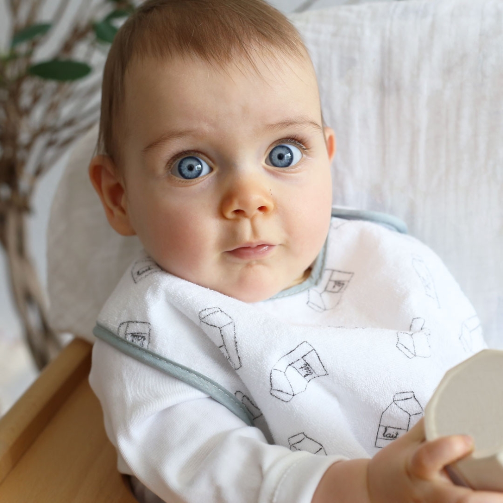 Baby in large gray milky baby bib
