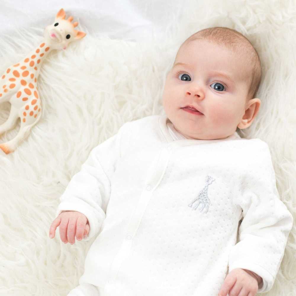 Bebé com pijama de veludo e a sua Sophie, a girafa