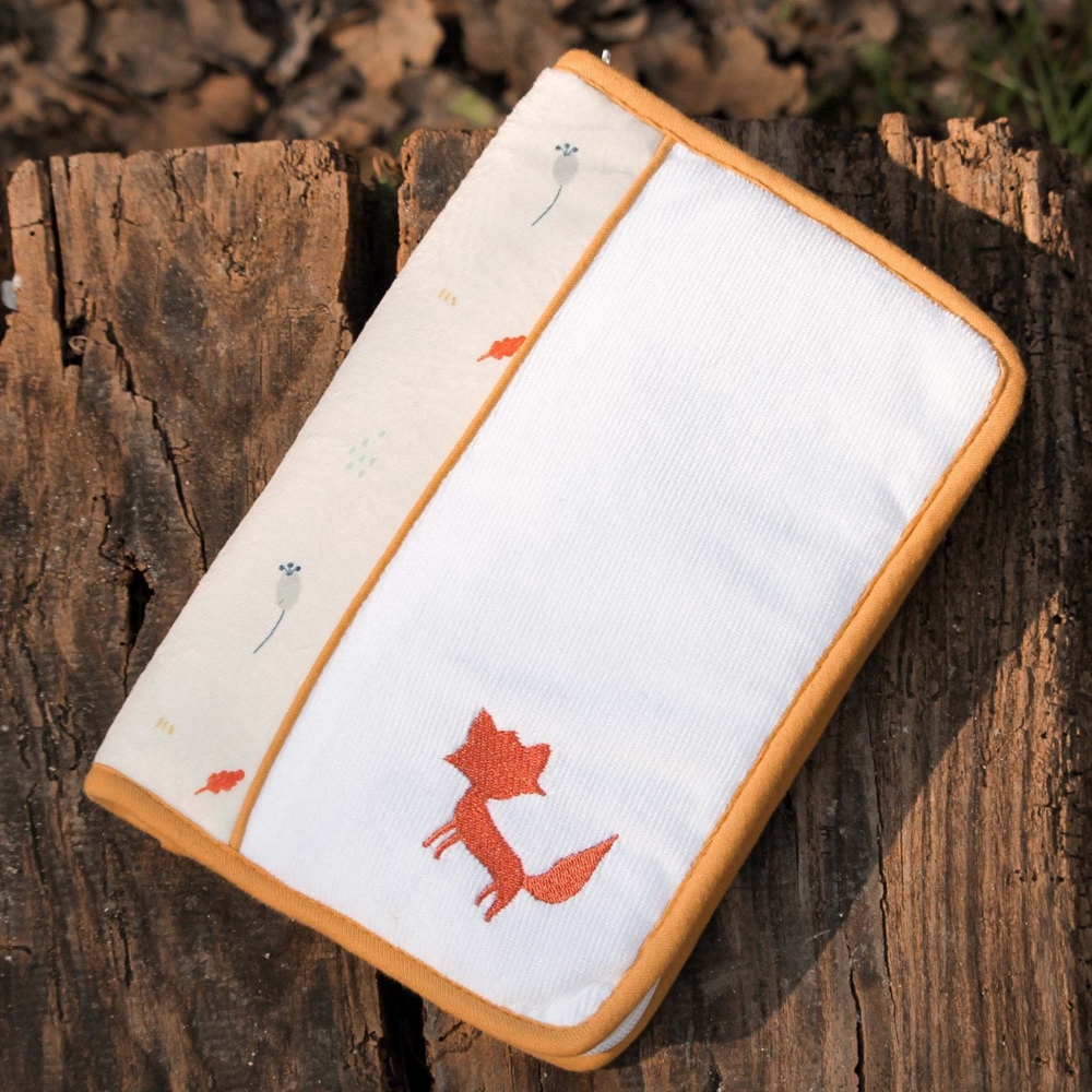 Protège carnet de santé posé sur un banc en bois Protège carnet de santé posé sur un banc en bois