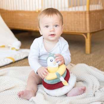 Baby spielt mit seiner weichen stapelbaren Pyramide mit Eulengesicht