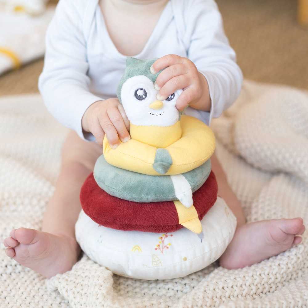 Sitzendes Baby, das die stapelbare Pyramide hält