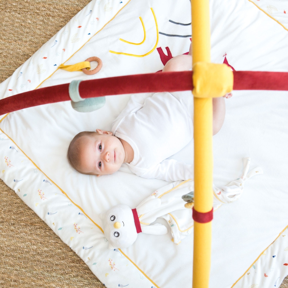 Bébé allongé sur son tapis avec arches Bébé allongé sur son tapis avec arches