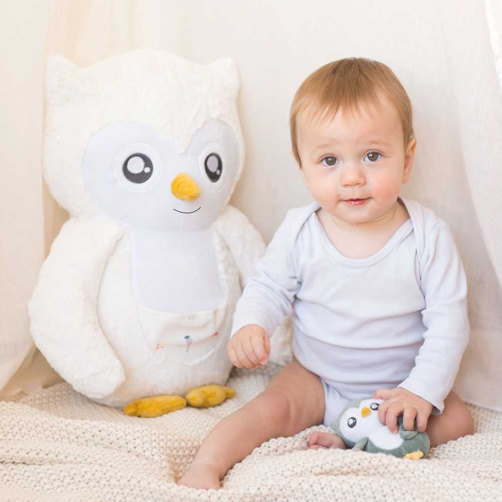 Peluche Violette ao lado do bebé na área de brincar Peluche Violette ao lado do bebé na área de brincar