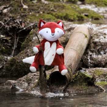 Fantoche Léonard, a raposa, numa cena à beira de um rio na floresta