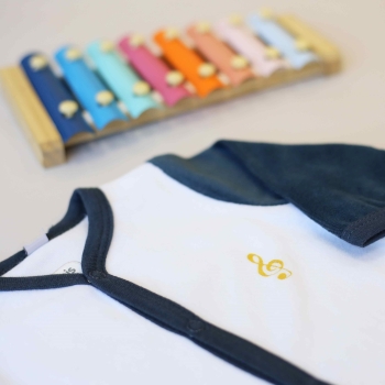 Embroidered musical note on newborn sleepsuit