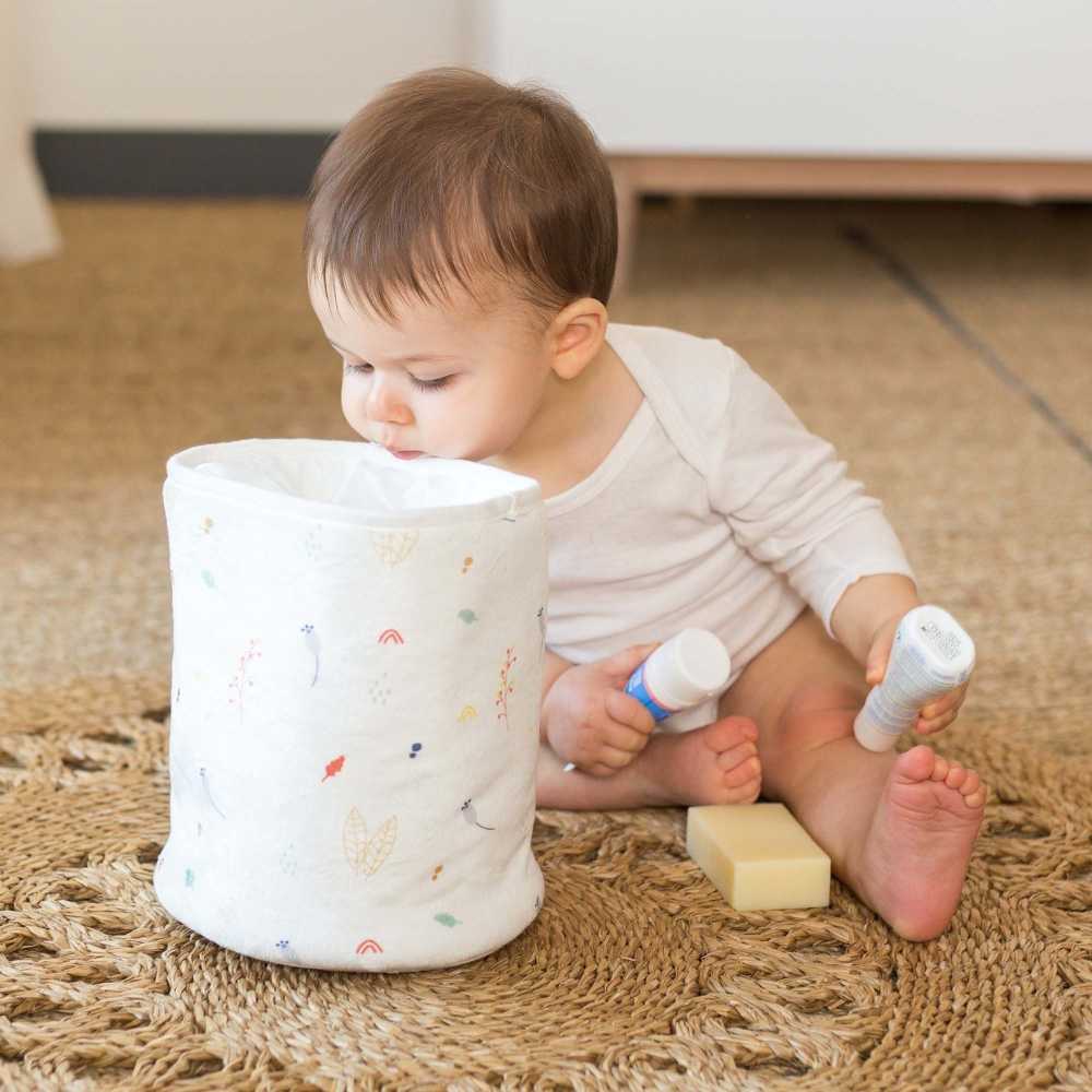 Bebé a olhar para dentro do saco de arrumação para tirar os produtos Bebé a olhar para dentro do saco de arrumação para tirar os produtos