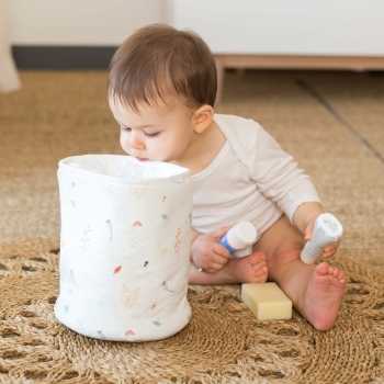 Bebé a olhar para dentro do saco de arrumação para tirar os produtos Bebé a olhar para dentro do saco de arrumação para tirar os produtos