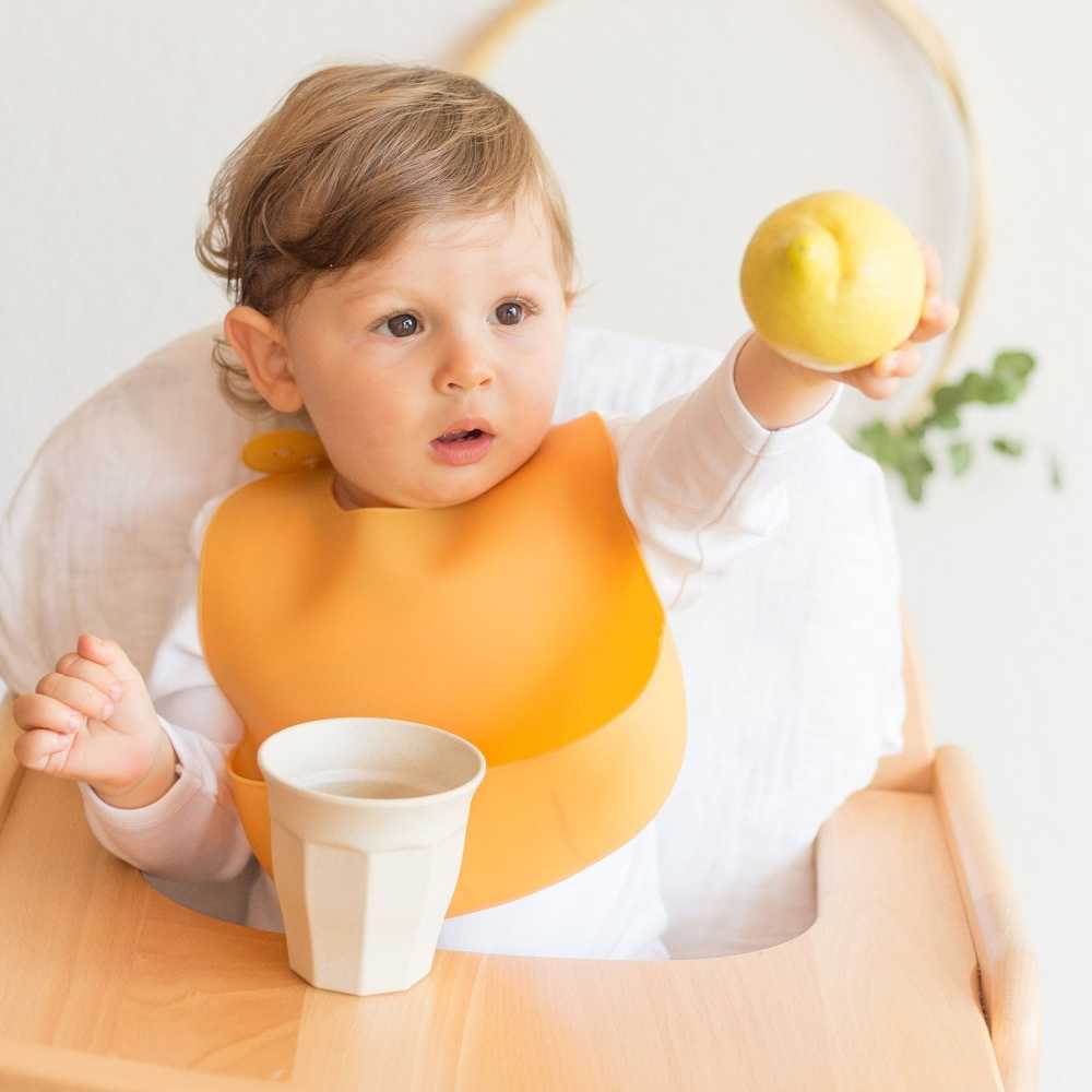 Bebé à mesa com o seu babete de silicone