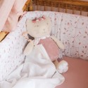 Pelúcia musical rosa na cama de bebé, com flores nas patas