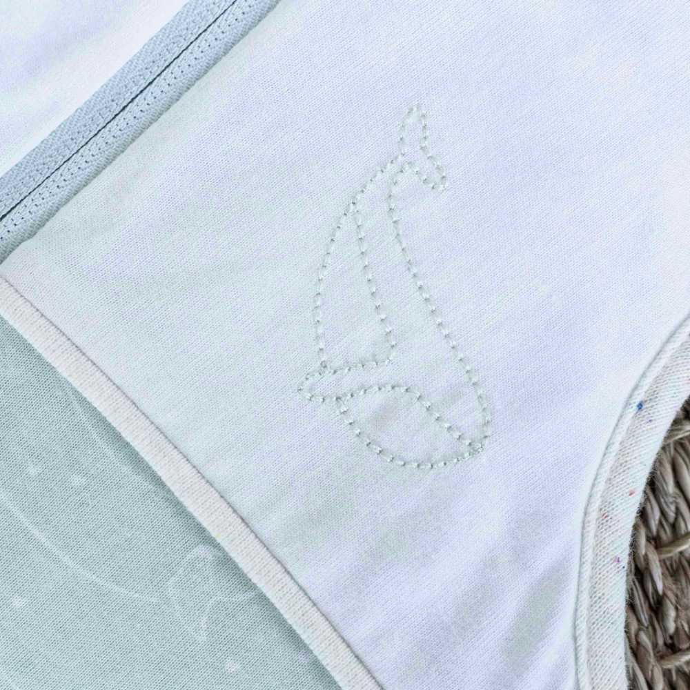 Pormenor do bordado de baleia verde-leite no saco de dormir para recém-nascido Au large de Nova Pormenor do bordado de baleia verde-leite no saco de dormir para recém-nascido Au large de Nova