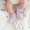 Les petits pieds d'un bébé sur le lance blanc aux motifs fleuris mauve