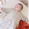 Bebé a dormir quentinho na cama, dentro do seu saco-cama com mangas e padrão de floresta Bebé a dormir quentinho na cama, dentro do seu saco-cama com mangas e padrão de floresta