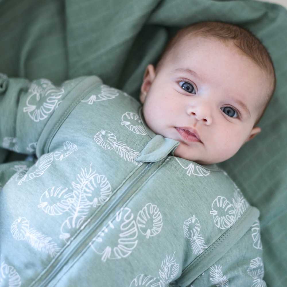 Bebé acordado no seu saco de dormir verde com mangas Bebé acordado no seu saco de dormir verde com mangas